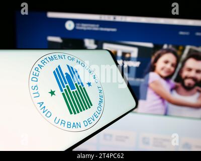 Smartphone with logo of US Department of Housing and Urban Development (HUD) in front of website. Focus on center-right of phone display. Stock Photo