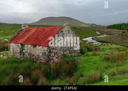 An old, rusty tin roof cottage near Maam Cross, Connemara, Galway, Ireland. Stock Photo
