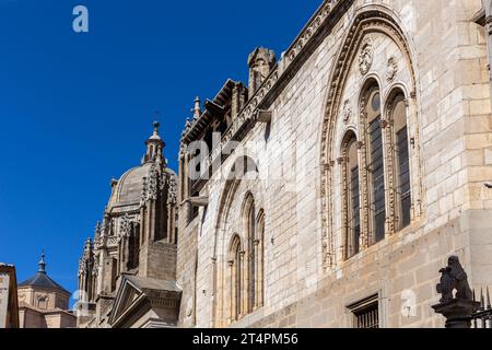 Toledo Cathedral (The Primatial Cathedral of Saint Mary of Toledo) richly decorated Gothic facade with carved windows arches, spires and dome. Stock Photo