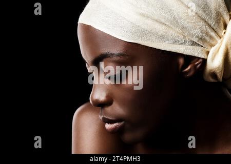 The definition of beauty. Studio shot of a beautiful woman wearing a headscarf against a black background. Stock Photo