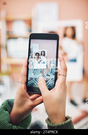 Lets start a trend. two young women posing with a social media prop while having their picture taking on a smartphone. Stock Photo