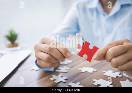 person hand connecting jigsaw puzzle pieces, business solutions, goals, success, goals and strategy concept, teamwork concept. Stock Photo
