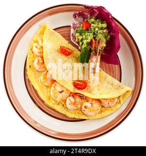 Omelette with shrimps, cheese and avocado and shrimp salsa served with cherry tomatoes, isolated on white background. Stock Photo