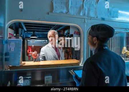 King Charles III visits Desi Loco Indian Street Food stand and orders a saag paneer kathi roll and a butter chicken samosa during a visit to a Nairobi Street Kitchen to celebrate the Kenyan cultural and creative scene and meet young creatives including artisans, fashion designers, musicians and artists, on day two of the state visit to Kenya. Picture date: Wednesday November 1, 2023. Stock Photo