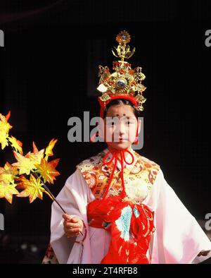 Japan. Tokyo. Autumn Festival. Local girl in traditional dress holding Maple branch. Stock Photo