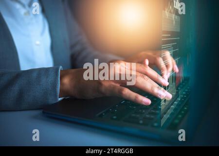 Doing business in a digital age. an unrecognisable businesswoman sitting alone in the office and using her laptop. Stock Photo