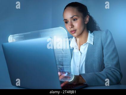 Im the code master. an attractive young businesswoman sitting alone in the office and using her laptop. Stock Photo