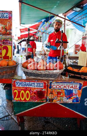 Sicily, Italy - June 22, 2022: A man selling fresh fruit juice in the market of palermo Stock Photo