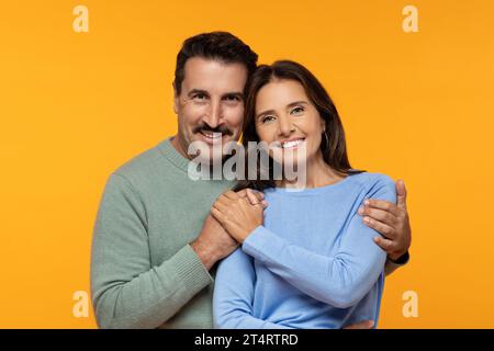 Happy senior european husband and wife in casual clothes hug and looking at camera Stock Photo
