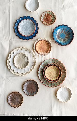 Ceramic scallop plates and bowls in various coloured glazes Stock Photo