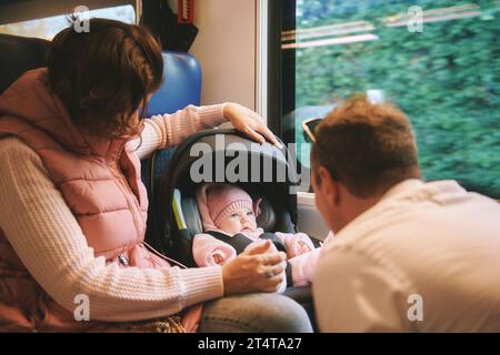 Young happy parents traveling with little baby by train Stock Photo