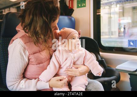 Young happy mother traveling with little baby by train Stock Photo