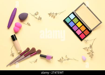 Frame made of makeup products and beautiful flowers on beige background Stock Photo