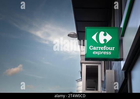 Picture of a sign with the logo of Carrefour Express in front of their local store in downtown Liege, belgium. Carrefour Express is a chain of proximi Stock Photo