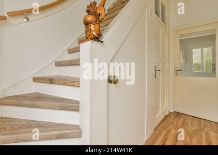 a wooden staircase in a house with white walls and wood flooring the stairs are made from solid planks Stock Photo