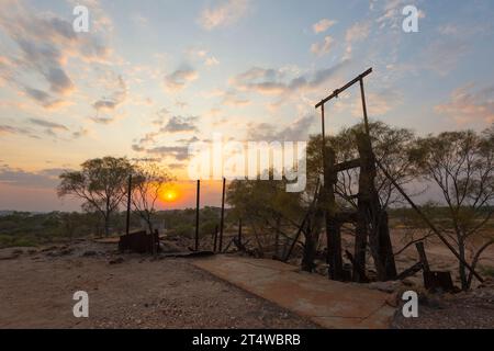 Atmospheric sunrise over discarded machinery at the Twenty Mile Sandy Creek old goldmine in the goldfields, Skull Springs Road, Pilbara, Western Austr Stock Photo