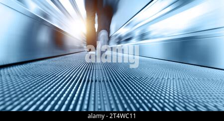 People walking at moving escalator in airport Stock Photo