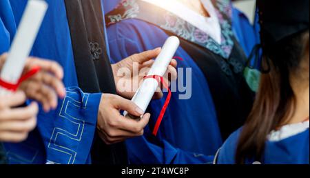 People in gowns holding a diploma Stock Photo