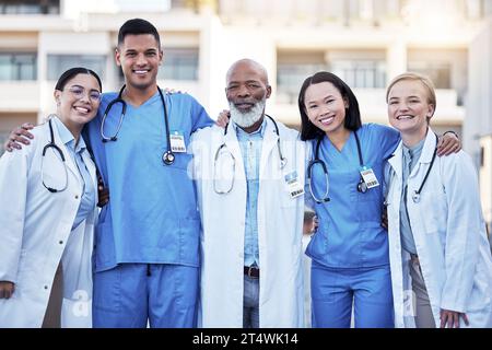 Portrait, healthcare and doctors with nurses in medicine standing outside a hospital as a team you can trust. Medical students, collaboration or Stock Photo