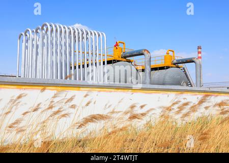 Silver metal radiator and storage tanks under blue sky Stock Photo - Alamy