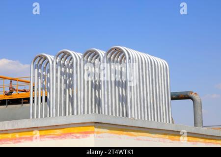 Silver metal radiator and storage tanks under blue sky Stock Photo - Alamy