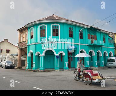 Classic local rickshaw in George Town with heritage photo studio as background , Penang, Malaysia. Stock Photo