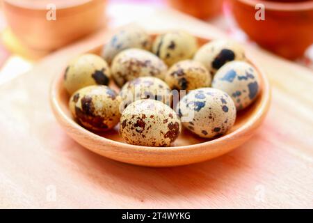 Quail eggs in a wooden bowl on a wooden background, Selective focus. Stock Photo