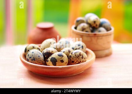 Quail eggs in a wooden bowl on a wooden background, Selective focus. Stock Photo