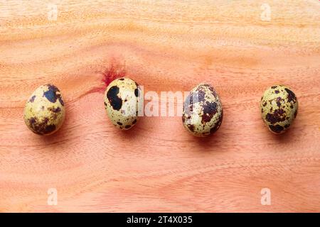 Quail eggs on a wooden background. Quail eggs in a row Stock Photo