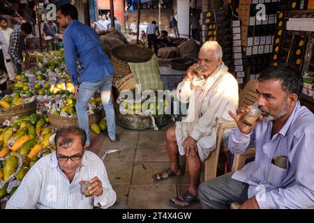 Indian men working at Crawford Market in Mumbai, India, having a tea break, drinking the customary Indian milk tea Stock Photo