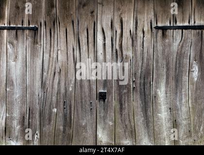 Old grey weathered wooden barn door with forged metal parts. Rustic Style. Copy space. Stock Photo