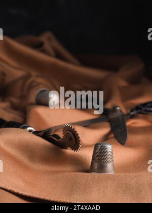 Close up of old used sewing utensils on a stylish fabric, handmade concept, manufacturing background Stock Photo