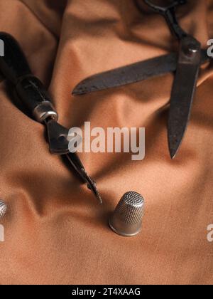 Close up of old used sewing utensils on a stylish fabric, handmade concept, manufacturing background Stock Photo