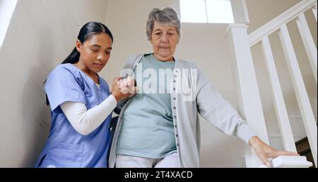 Senior woman, nurse and help on stairs, retirement home and caregiver for support, trust and nursing. Careful, empathy and elderly for healthcare Stock Photo