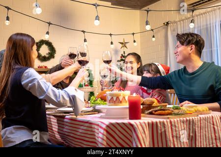 Happy people are celebrating on a table meal when christmas and new year at home. Cheerful elder , daughter ,son and child are eating dinner food with Stock Photo