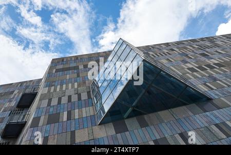 Rectangle marble stone tiles wall and triangle glass window of modern building exterior Stock Photo