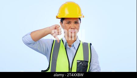 Woman, thumbs down and engineer for construction by architect in studio by blue background. Asian female, development and negative review for real Stock Photo