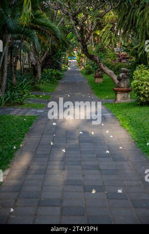 Park with tropical plants and traditional statues of the Hindu faith and for decoration. Tropical island life as a tourist on Bali, Indonesia Stock Photo
