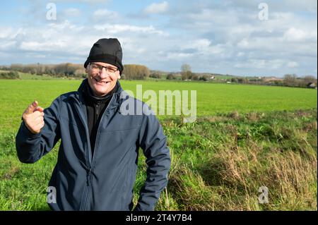 Active 45 yo white man with bonnet standing in the green fields around Gooik, Brabant, Belgium Stock Photo