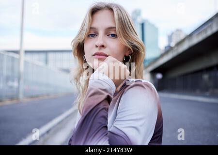 Woman in city street, fashion portrait for blonde model and gen z style in New York road. Outdoor winter clothes, natural makeup beauty on face and Stock Photo