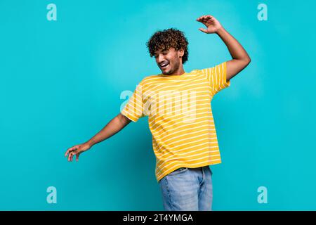 Portrait of overjoyed carefree young man enjoy dancing partying have good mood isolated on cyan color background Stock Photo
