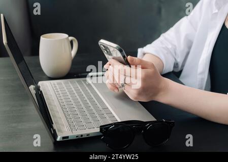 Professional Businesswomen Multitasking with Laptops and Smartphones in Modern Office. Diverse Female Managers Engaged in Internet Marketing at Office Stock Photo