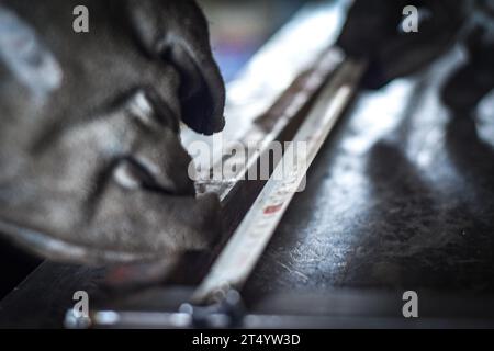 Man measuring off metal bar in industrial workshop. near Kocani Macedonia Stock Photo