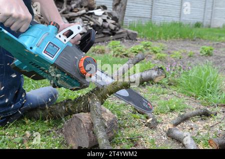 Working with Power Tools. An electric saw in the hands of a man. Stock Photo