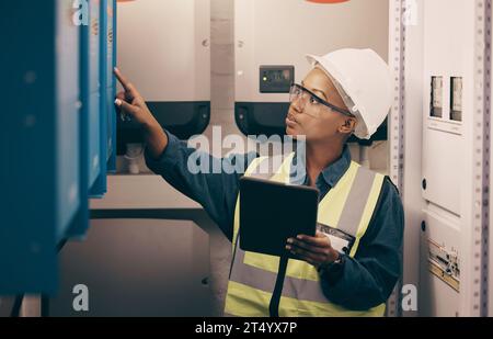 Engineering, black woman or electrician on tablet for maintenance, server or machine board system. Female technician, digital technology or electrical Stock Photo