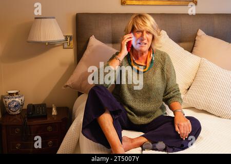 Attentive older woman talking on cell phone Stock Photo