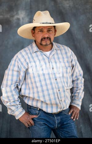 A Mexican cowboy taking part in the annual four-day Cabalgata de Cristo Rey cowboy pilgrimage on horseback poses for a portrait, January 5, 2019 in Salamanca, Guanajuato, Mexico. Thousands of Mexican cowboys and their horses join the religious journey from the high desert villages to the mountaintop shrine of Cristo Rey. Stock Photo