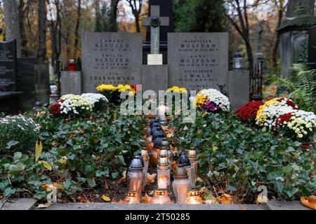 Flowers and lit candles stand on the grave on All Saints' Day at the Evangelical-Augsburg Cemetery in Warsaw. All Saints' Day (or Dzie? Zaduszny in Polish) is a public holiday in Poland. It is an opportunity to remember deceased relatives. On this day, people bring flowers, typically chrysanthemums, and candles to cemeteries. The entire cemetery is filled with lights in the darkness. The Evangelical-Augsburg Cemetery is a historic Lutheran Protestant cemetery located in the western part of Warsaw. Since its opening in 1792, more than 100,000 people have been buried there. Stock Photo