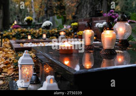 Flowers and lit candles stand on the grave on All Saints' Day at the Evangelical-Augsburg Cemetery in Warsaw. All Saints' Day (or Dzie? Zaduszny in Polish) is a public holiday in Poland. It is an opportunity to remember deceased relatives. On this day, people bring flowers, typically chrysanthemums, and candles to cemeteries. The entire cemetery is filled with lights in the darkness. The Evangelical-Augsburg Cemetery is a historic Lutheran Protestant cemetery located in the western part of Warsaw. Since its opening in 1792, more than 100,000 people have been buried there. (Photo by Volha Shuka Stock Photo