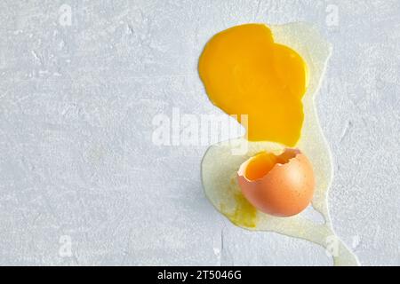 Broken and spread egg on a gray concrete floor Stock Photo